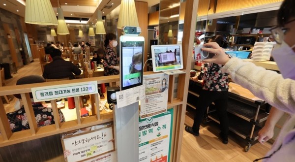 서울의 한 음식점 입구에 설치된 발열체크 기계와 QR코드 확인 단말기의 모습./사진=연합뉴스